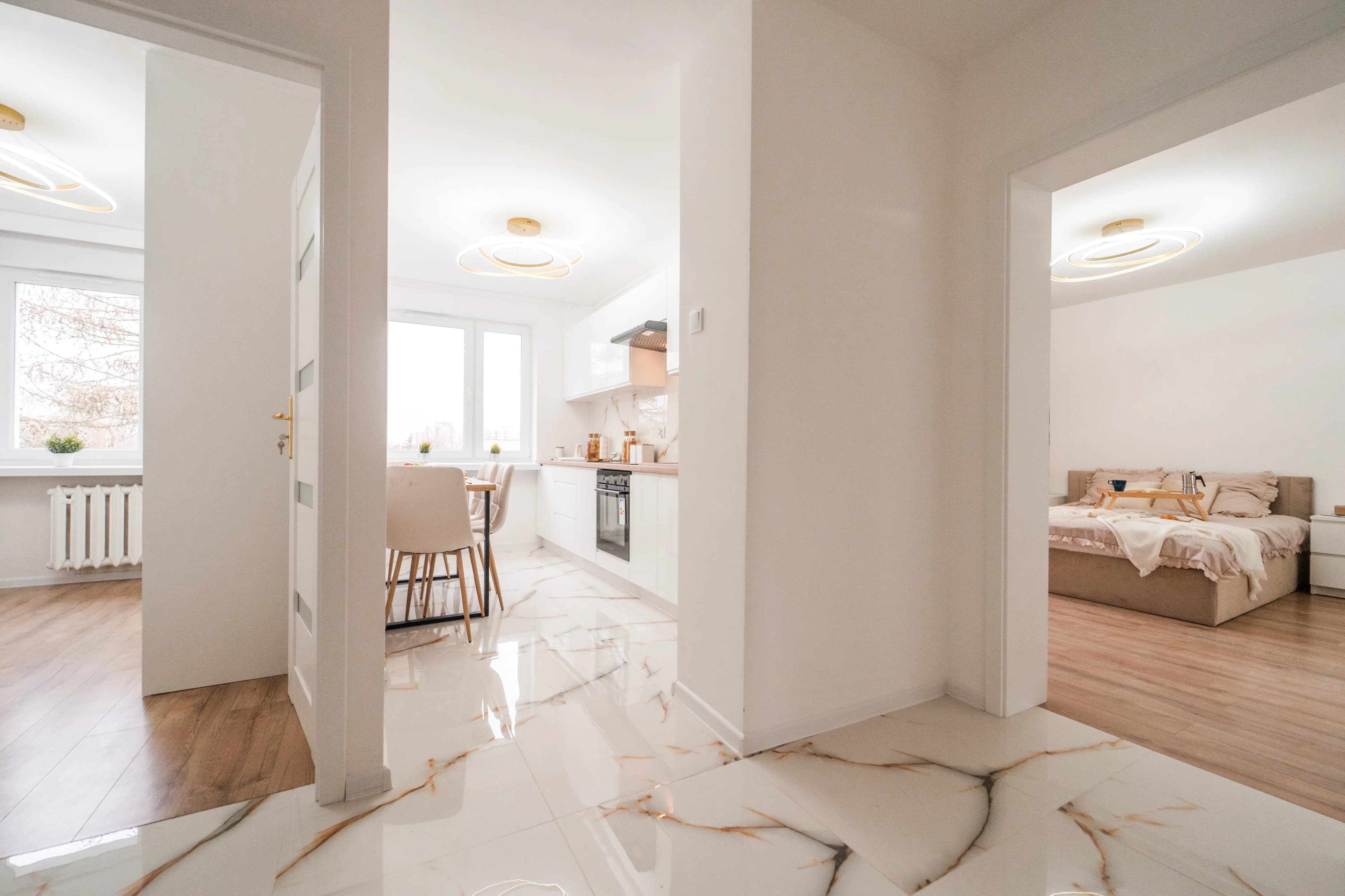 Nowocześnie wykończone wnętrze korytarz z widokiem na salon kuchnię i pokój.