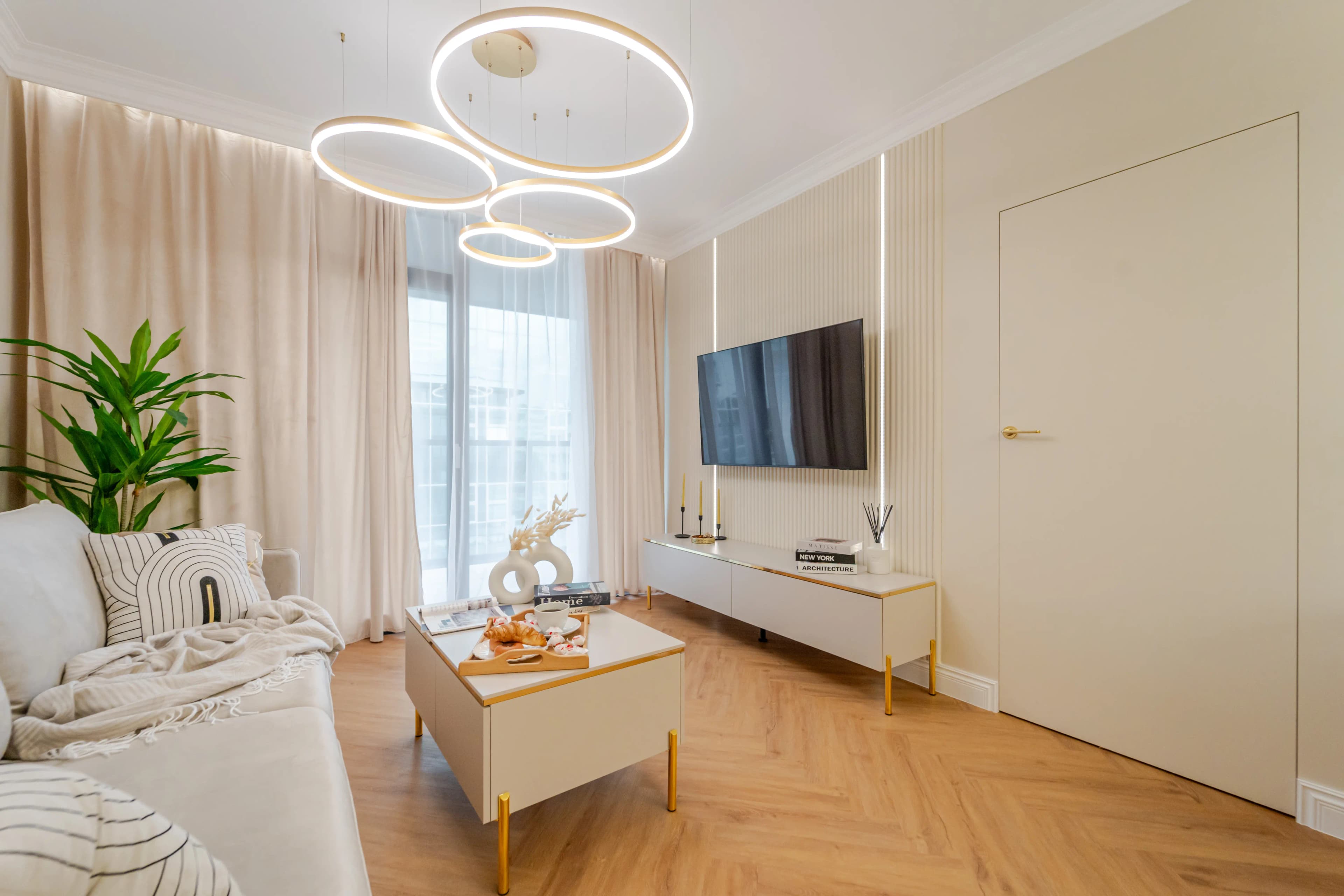 Bezowa sypialnia z dużym łóżkiem o prostym designie z stolikiem nocnym.