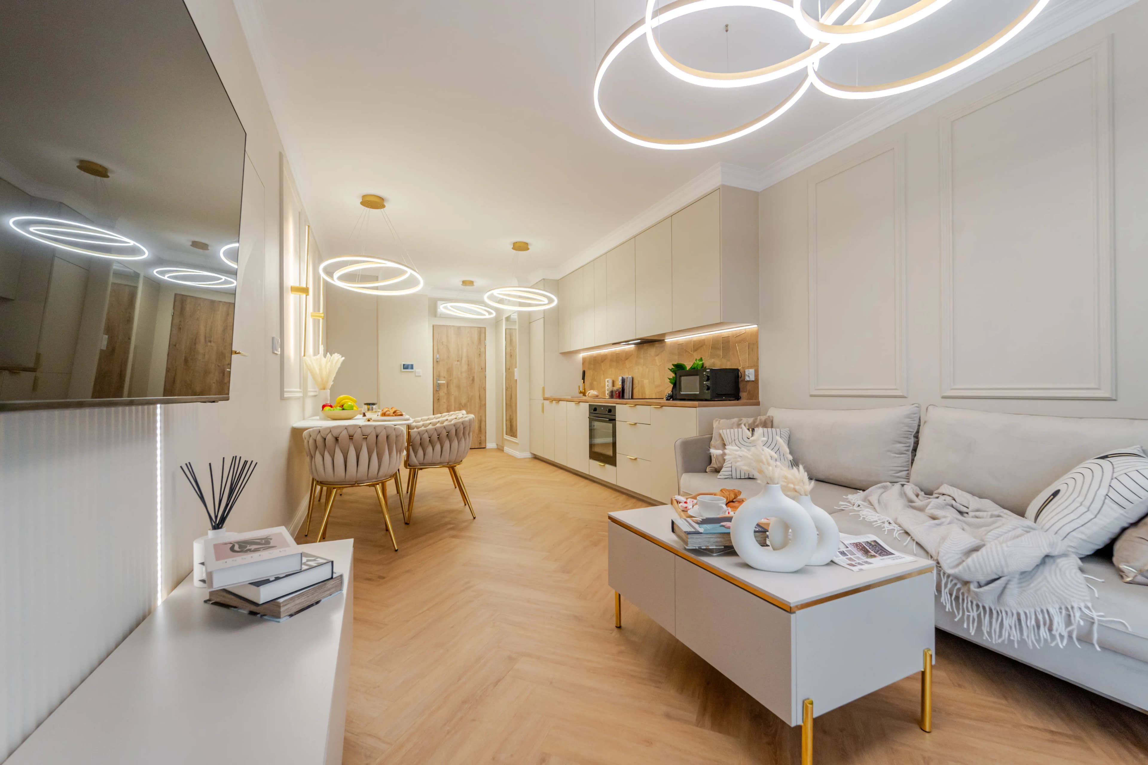 Mała kawlerka z aneksem kuchenym w odcienach szarości i zieleni.