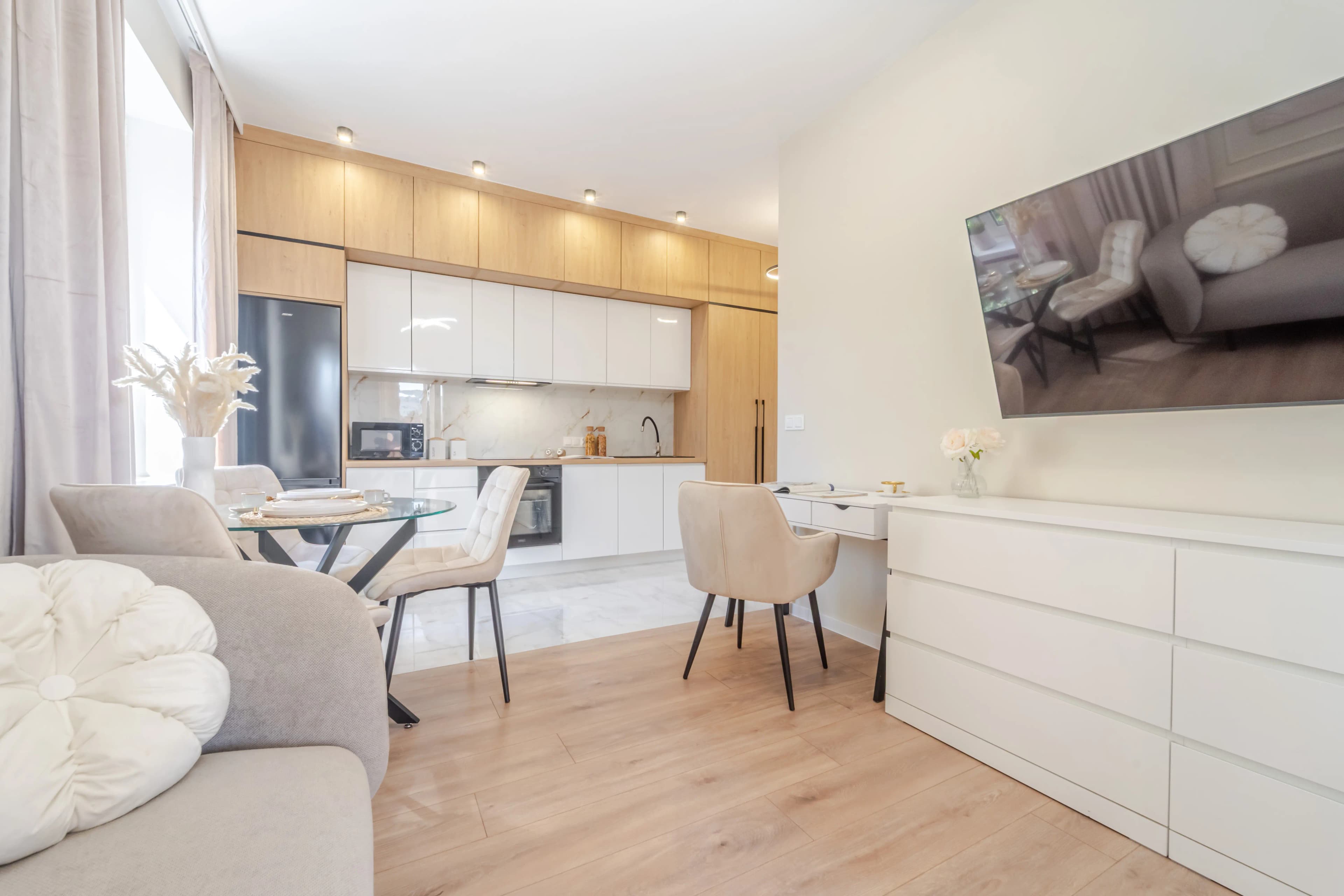 Jasna, elegancka sypialnia z dużym łóżkiem, toaletką i delikatnymi zasłonami.