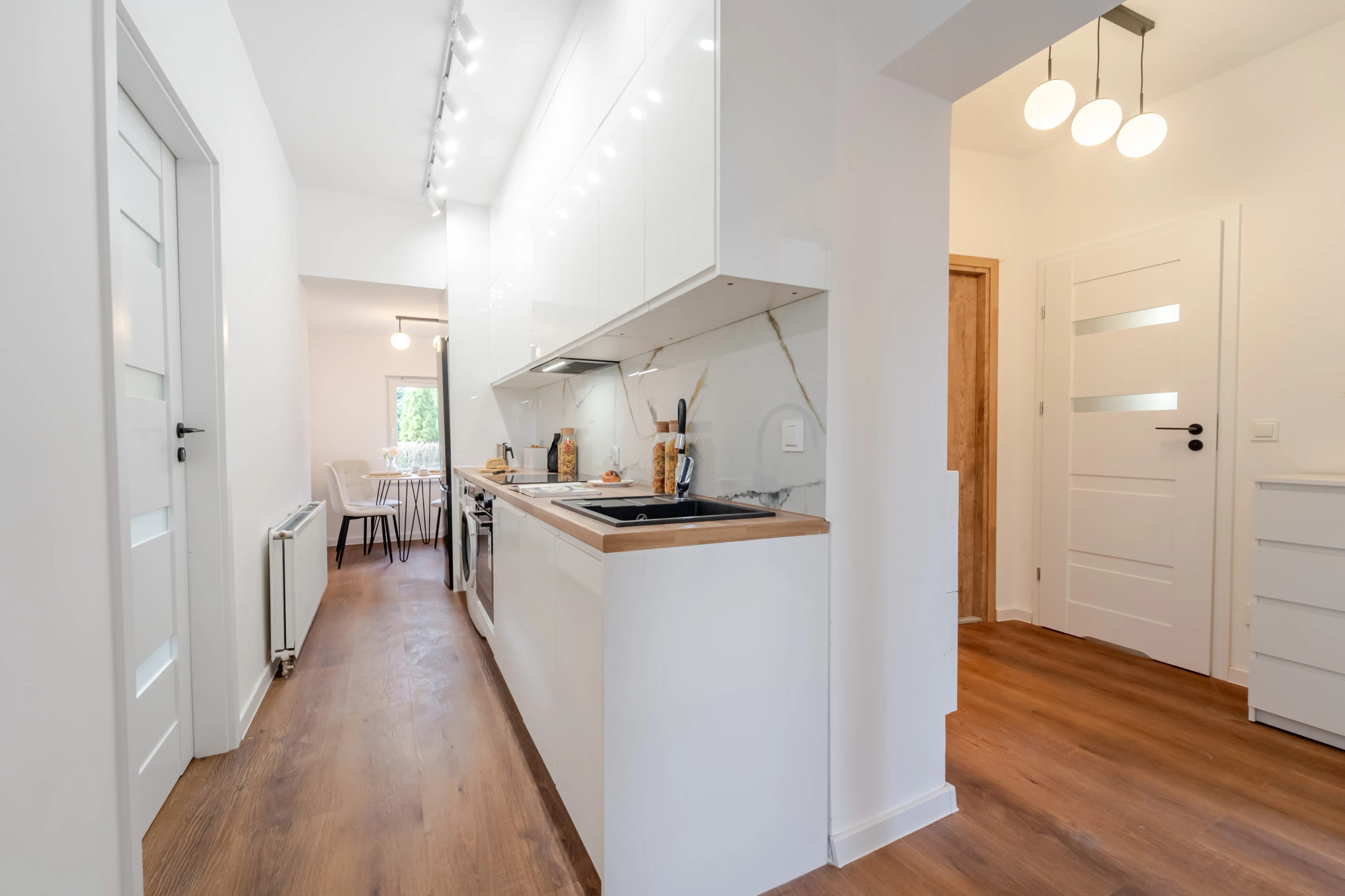 Nowoczesna, jasna sypialnia z dużym łóżkiem, tacą śniadaniową i szafą z lustrzanymi drzwiami. przez okno. Idealne miejsce do relaksu z książką.