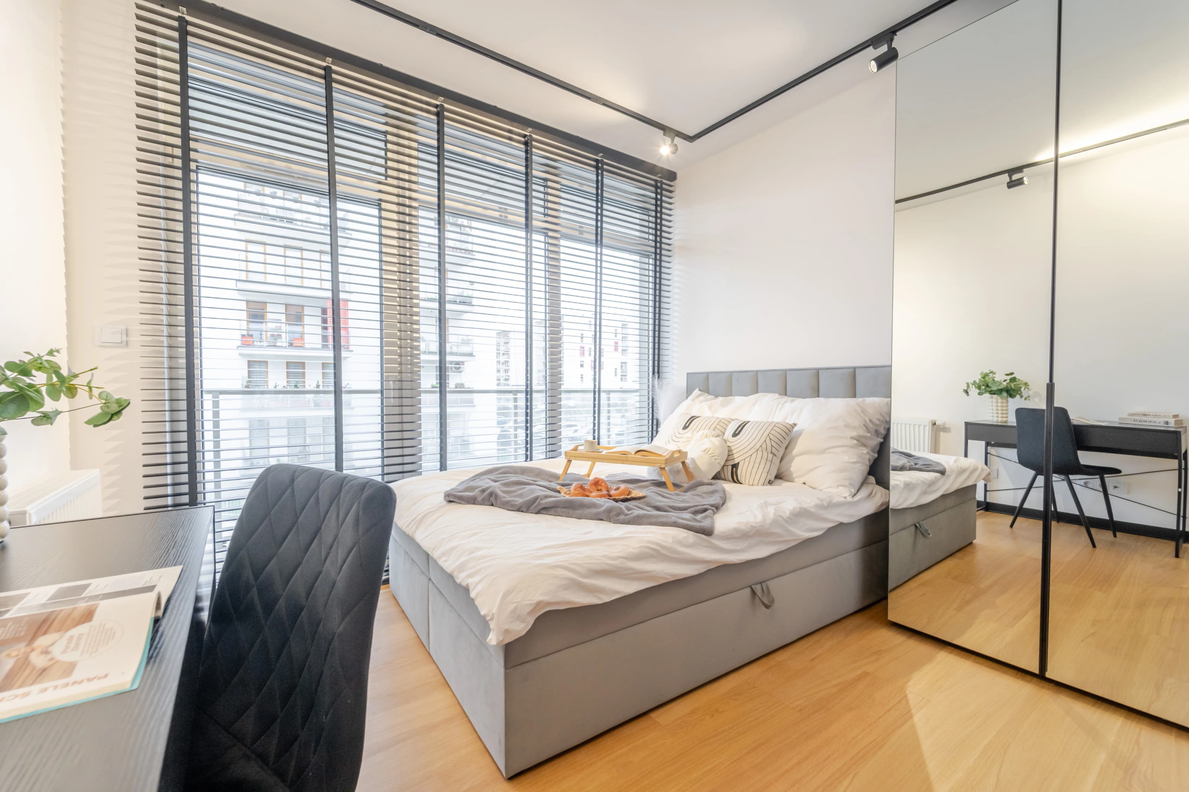 Jasny salon z aneksem kuchennym, jadalnią i częścią wypoczynkową w nowoczesnym stylu glamour.