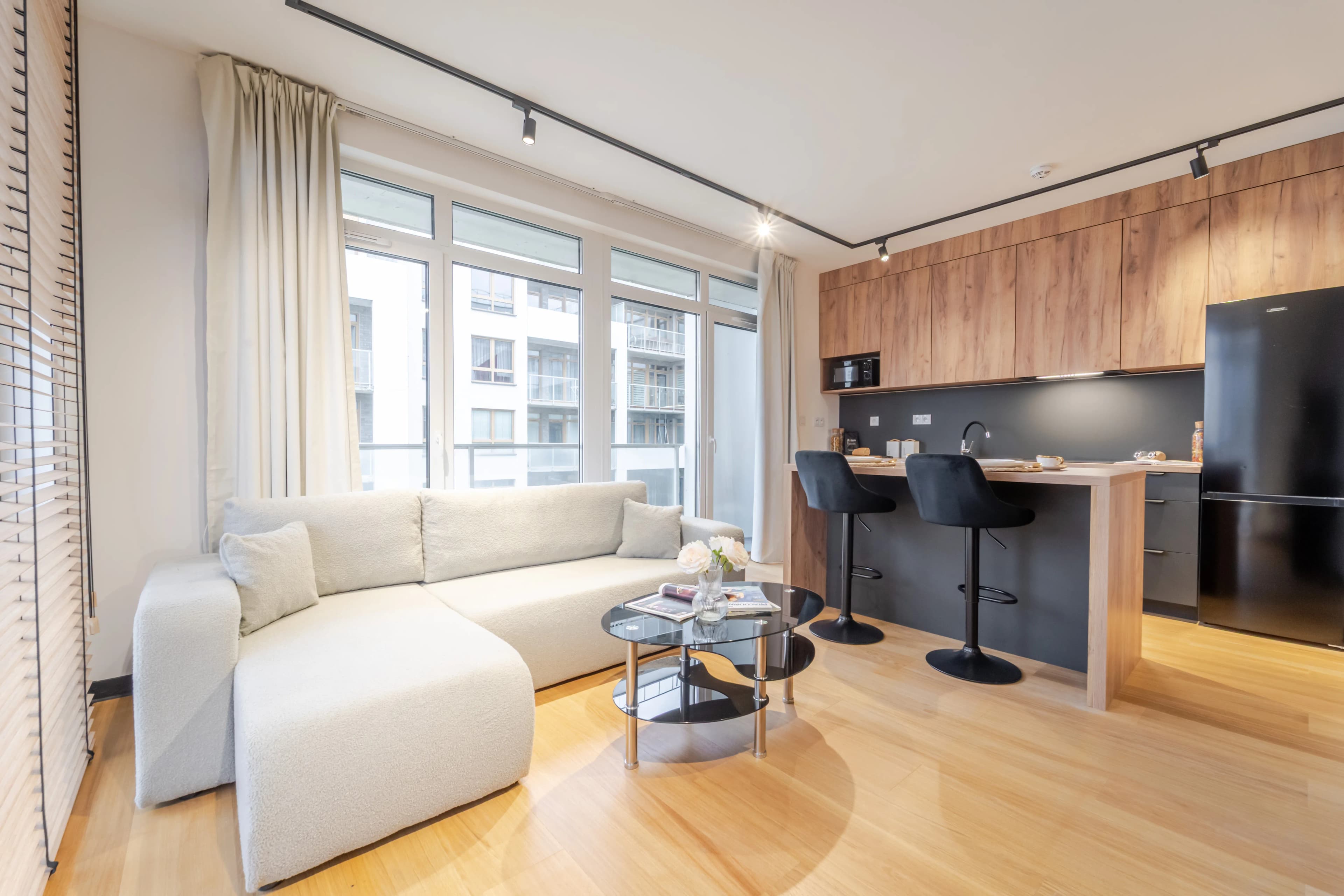 Jasna, przytulna sypialnia z drewnianą szafą, biurkiem i łóżkiem udekorowanym tacą śniadaniową