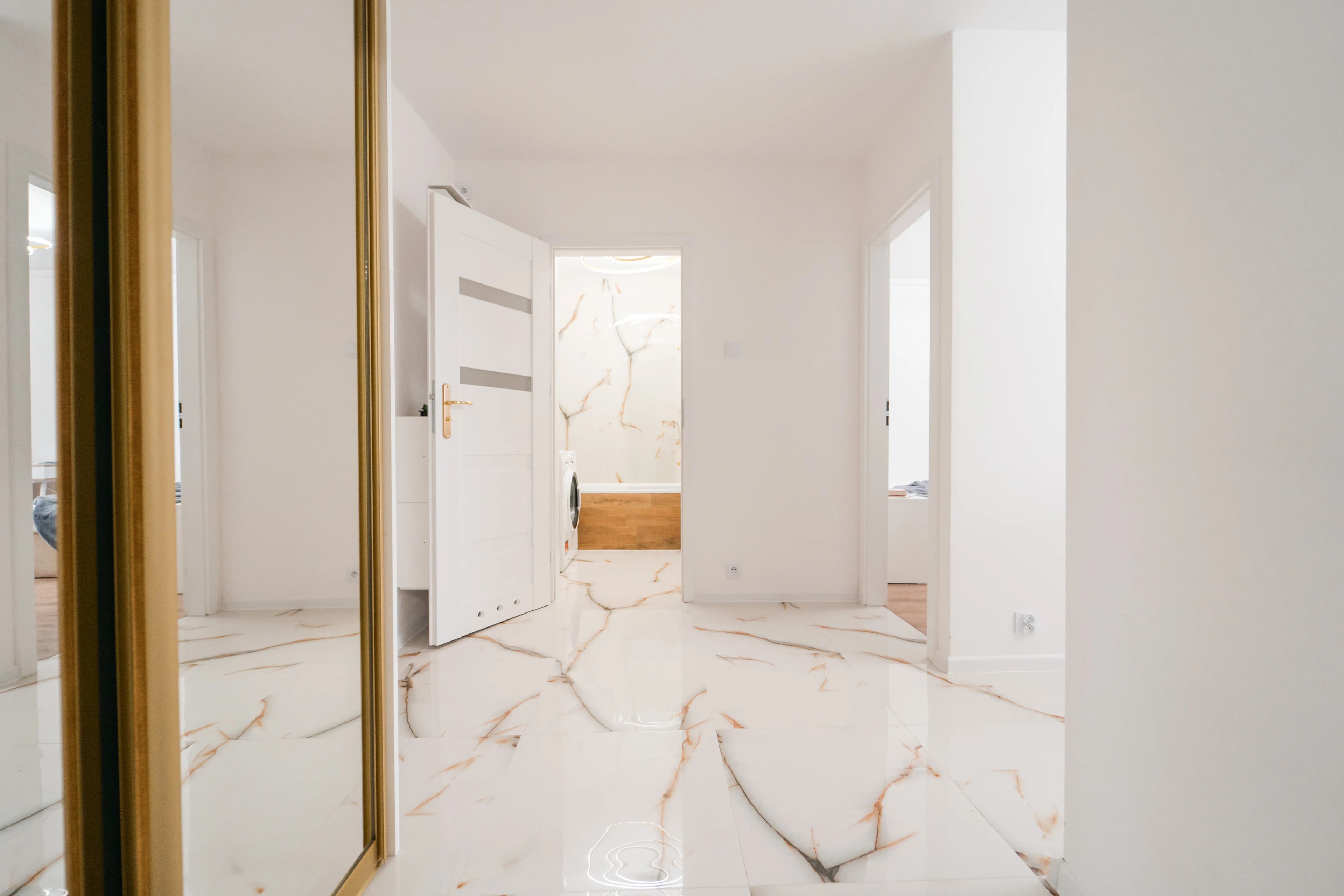 Kompletny widok sypialni z szafą przesuwną, wygodnym łóżkiem i jasnymi drzwiami, utrzymany w naturalnej kolorystyce.