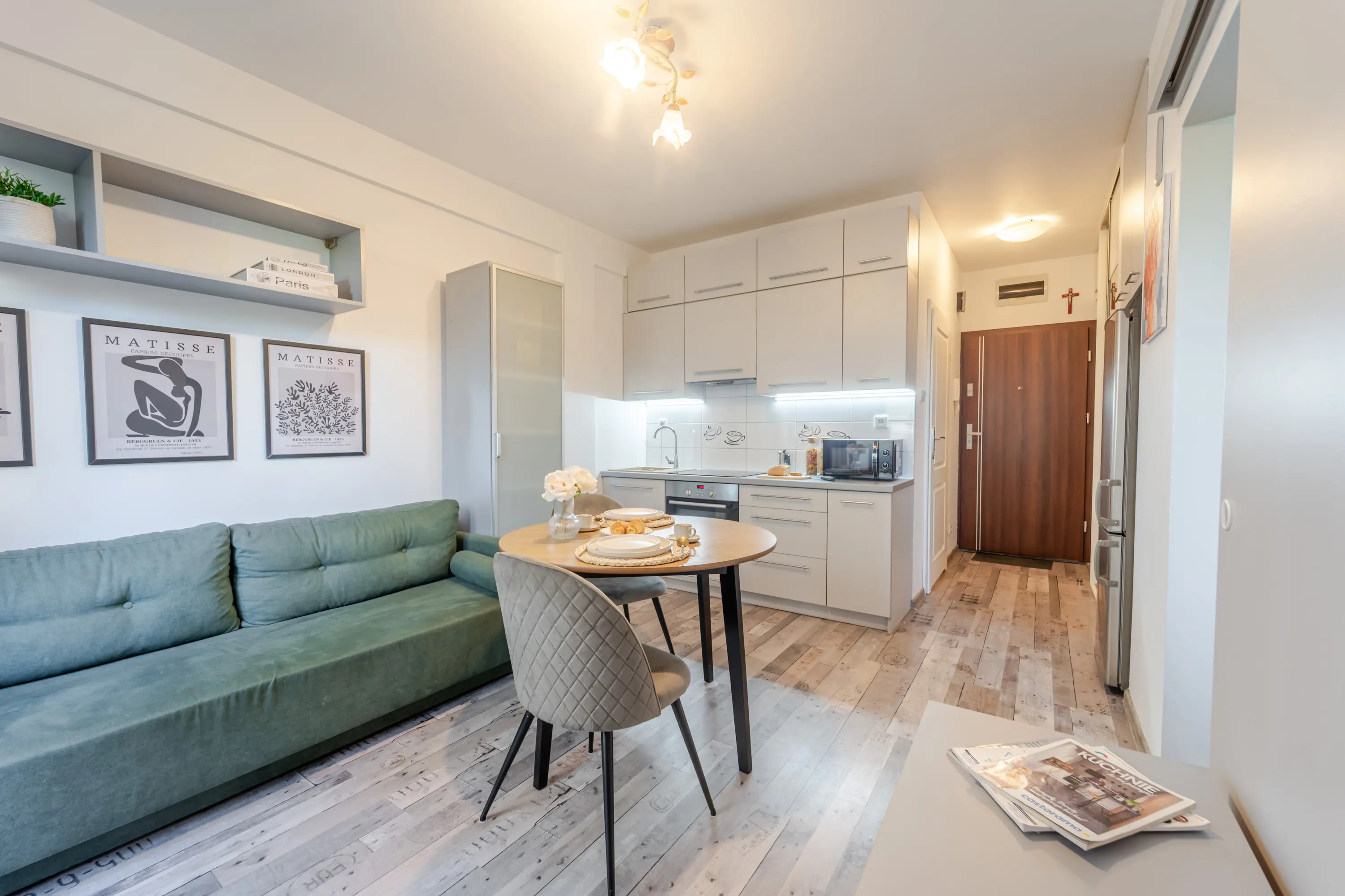 Przestronny pokój dzienny łączący strefę wypoczynkową z jadalnią, umeblowany klasycznymi, drewnianymi meblami.