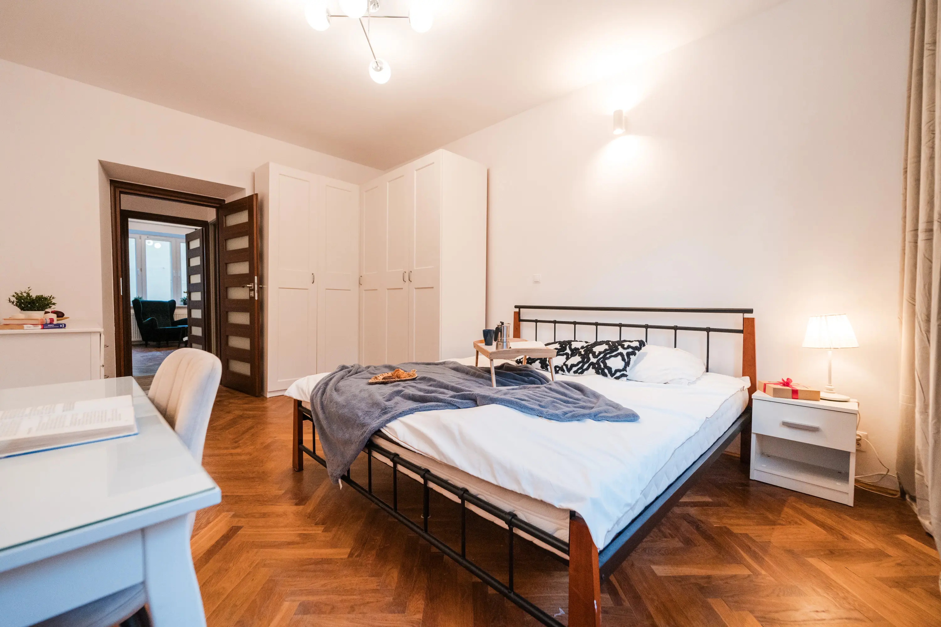 Aranżacja strefy relaksu z szarą kanapą, dywanem i drewnianą meblościanką w tradycyjnym stylu.