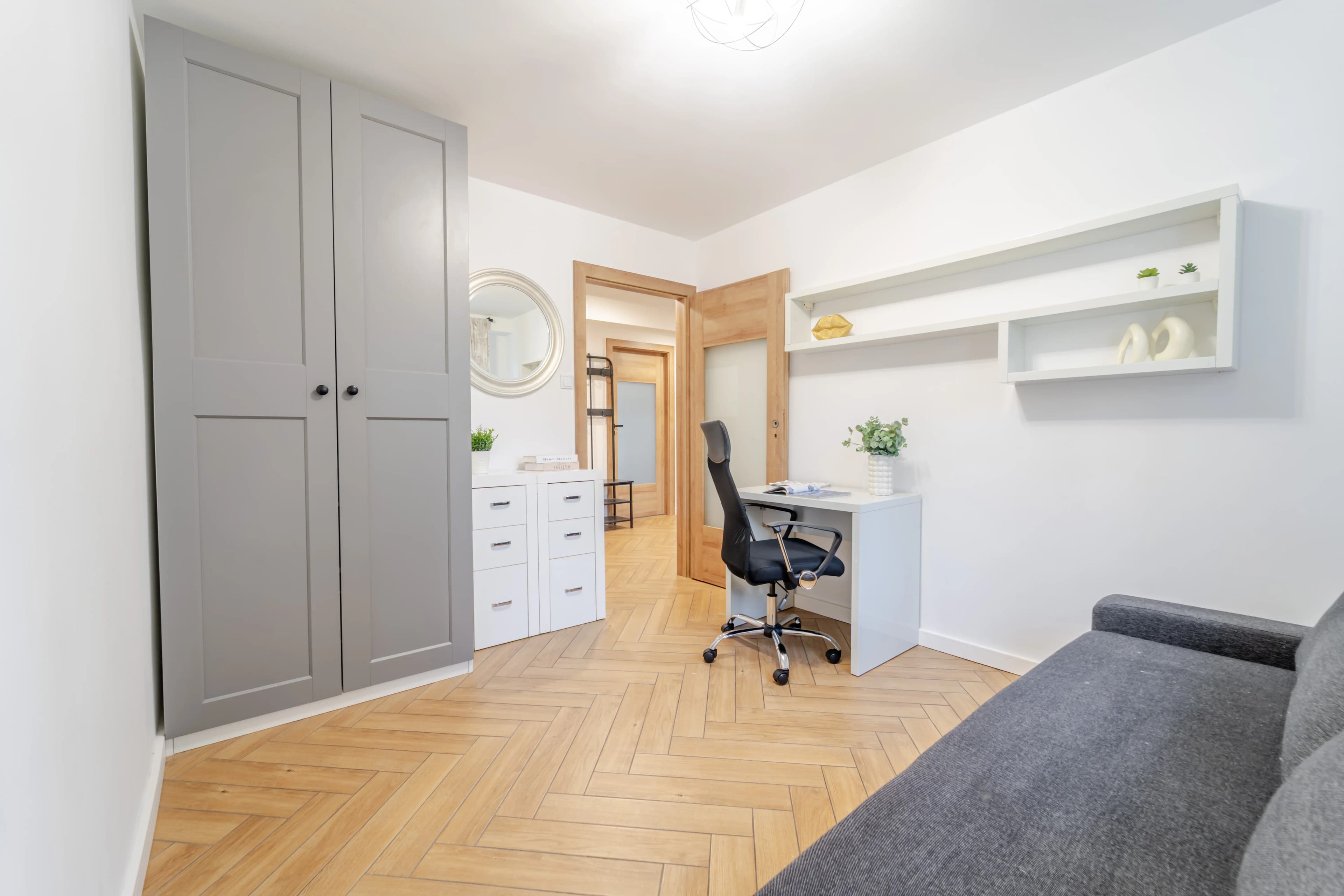 Widok na część jadalnianą usytuowaną przy oknie balkonowym z perspektywy kanapy.